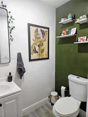 a bathroom with a toilet a sink and mirror