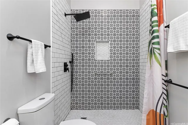 a bathroom with a toilet and a shower curtain