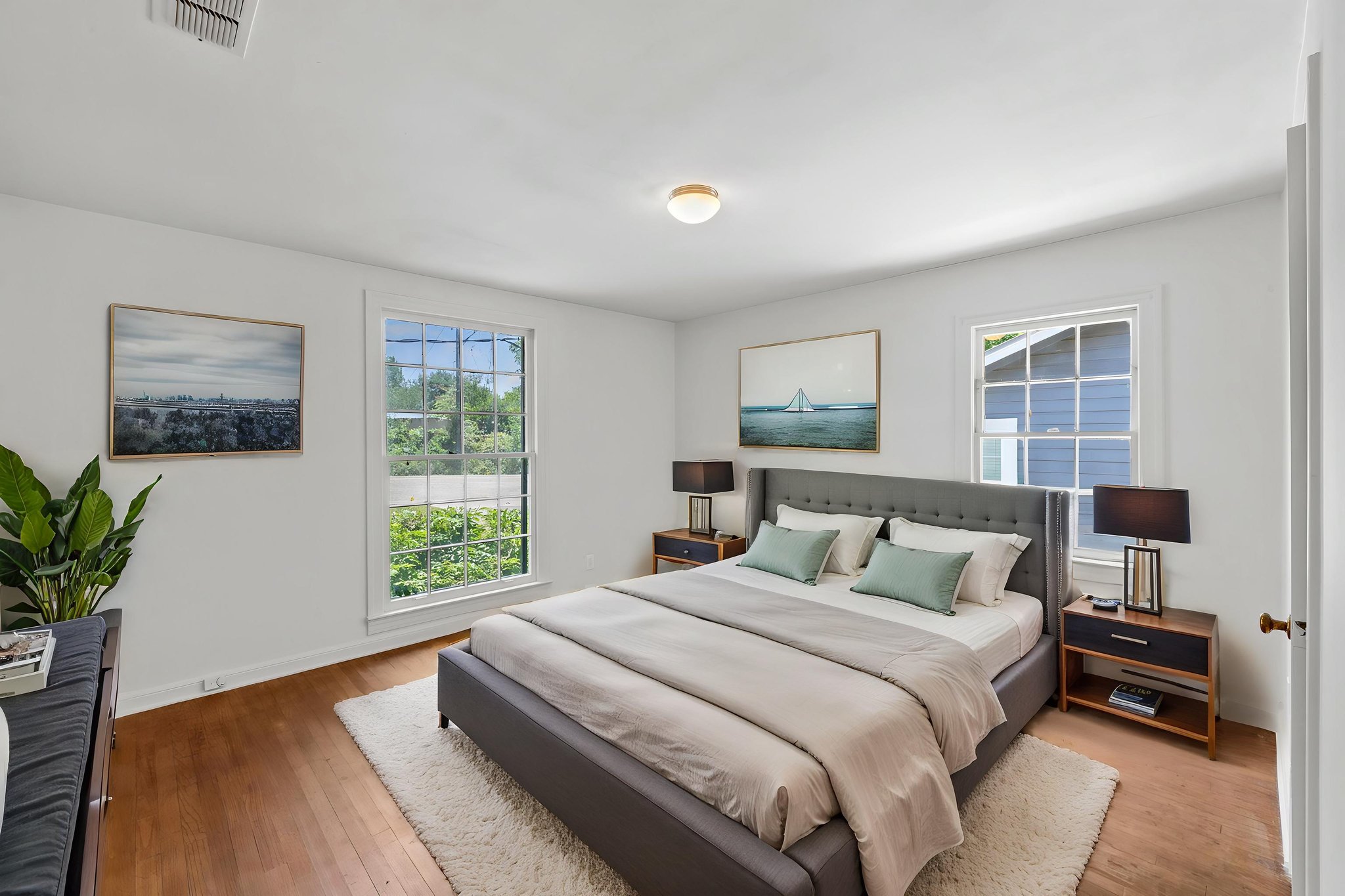 3704 Cherrywood Road Austin, TX 78722 - Photo 26 of 40 Sun-filled bedroom showcasing hardwood flooring and large windows with serene outdoor views.