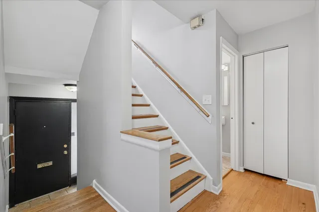 a view of a hallway with staircase and white walls