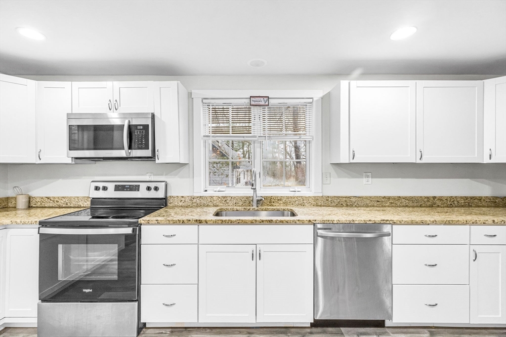 63 South Cottage Road Holland, MA 01521 - Photo 8 of 35 a kitchen with granite countertop a stove top oven microwave and cabinets