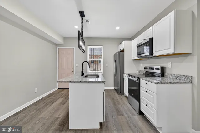 a kitchen with stainless steel appliances granite countertop a sink a stove and a refrigerator