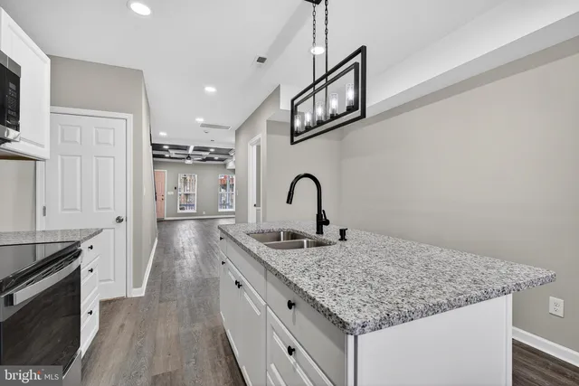 a kitchen with stainless steel appliances granite countertop a sink dishwasher and stove with wooden floor
