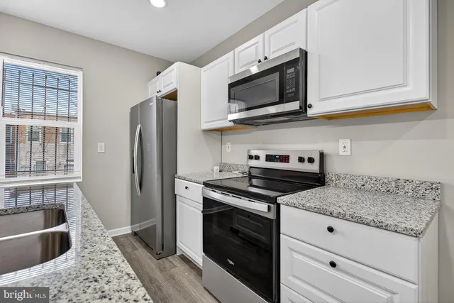 a kitchen with stainless steel appliances granite countertop a stove microwave and refrigerator