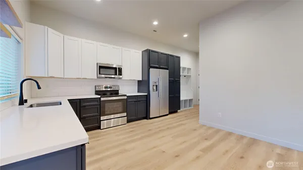 a kitchen with granite countertop a refrigerator and a stove top oven