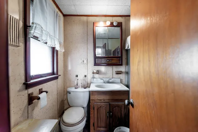 a bathroom with a toilet a sink and mirror