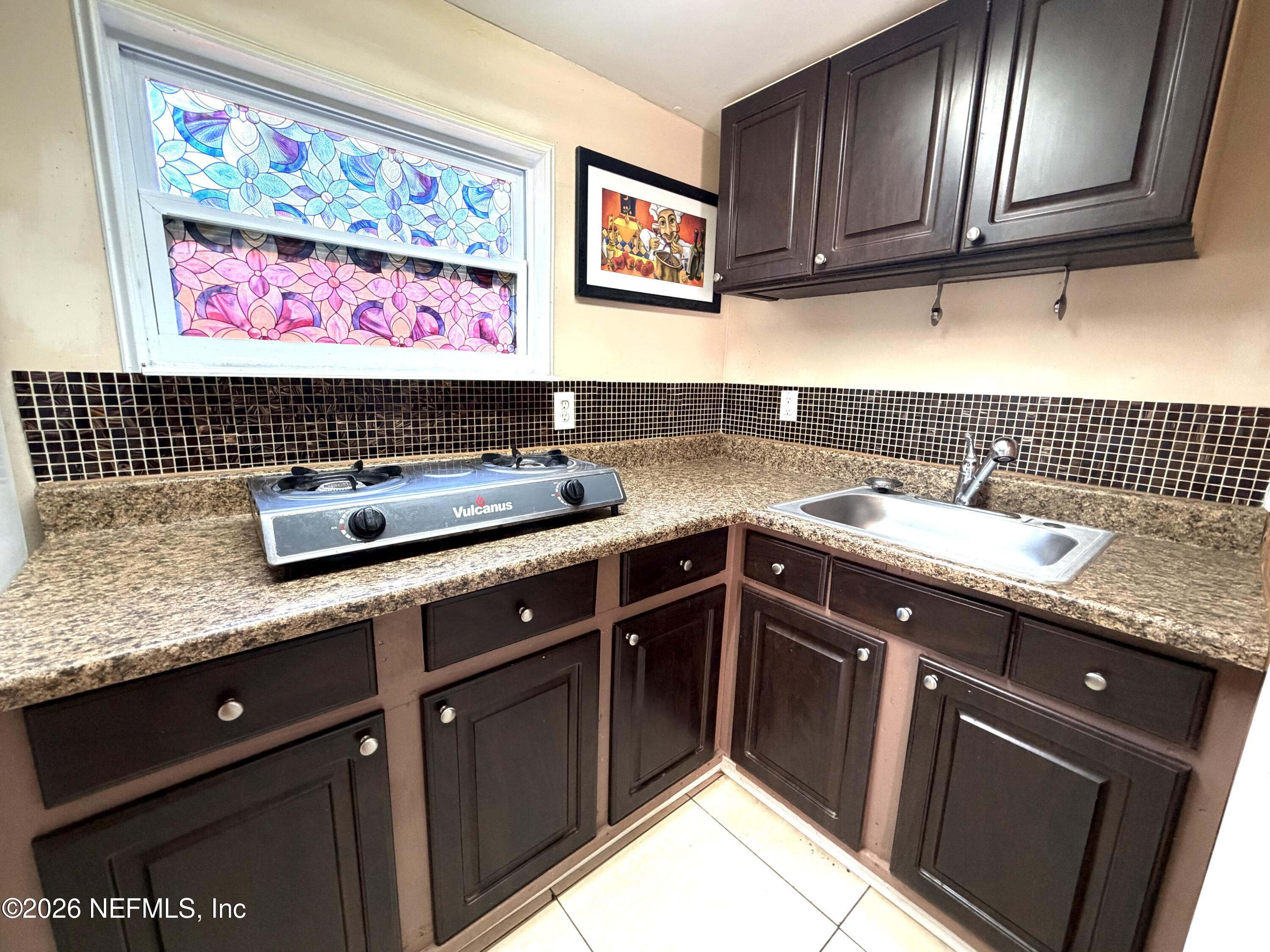 4127 Springwood Road Jacksonville, FL 32207 - Photo 56 of 63 a kitchen with stainless steel appliances granite countertop a sink stove and cabinets