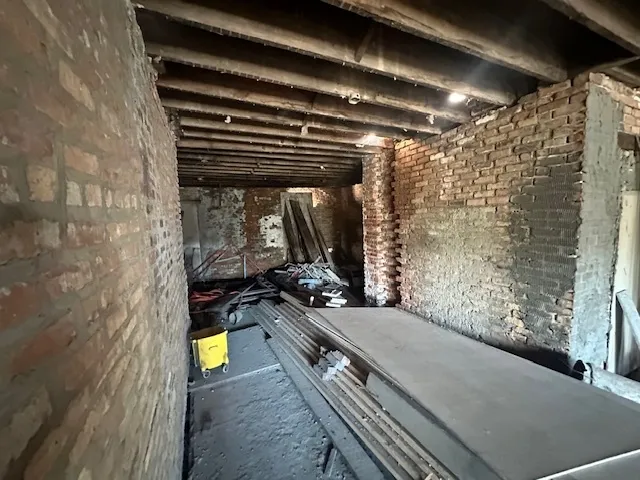 a room with water heater and a wooden floor