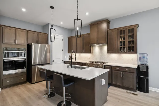 a kitchen with kitchen island a sink stove and refrigerator