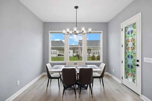 a view of a dining room with furniture a chandelier and wooden floor