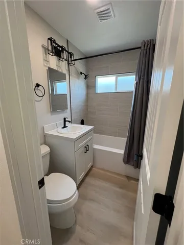 a bathroom with a sink a toilet a mirror and shower
