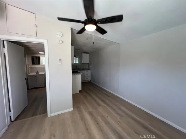 wooden floor in an empty room with a kitchen