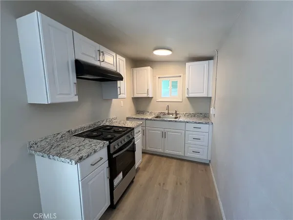 a kitchen with stainless steel appliances granite countertop a stove a sink and a microwave