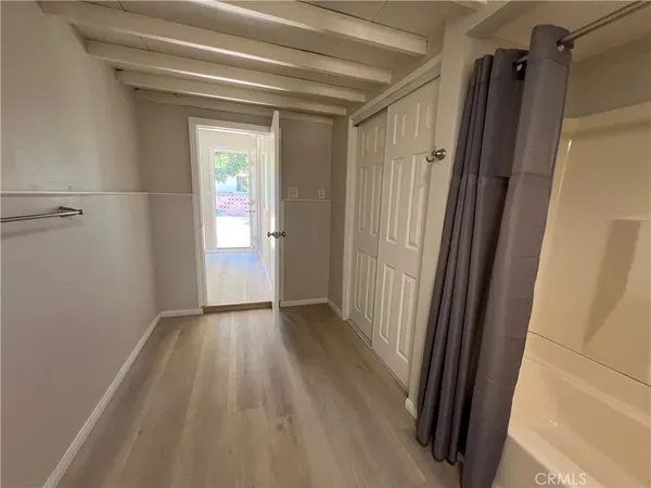 a view of a room with wooden floor and a window