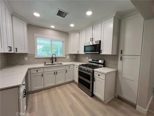 a kitchen with stainless steel appliances granite countertop a stove a sink and a refrigerator