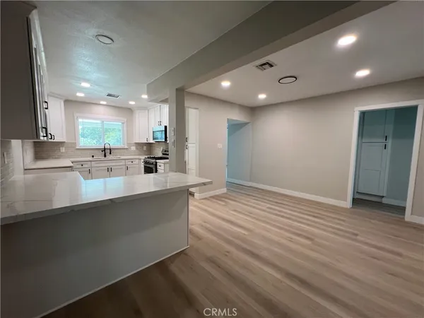 a large kitchen with stainless steel appliances a large counter top a stove and a refrigerator