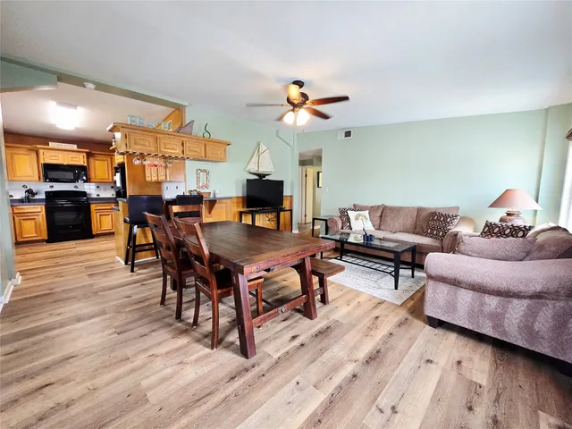 a living room with furniture a wooden floor and a chandelier