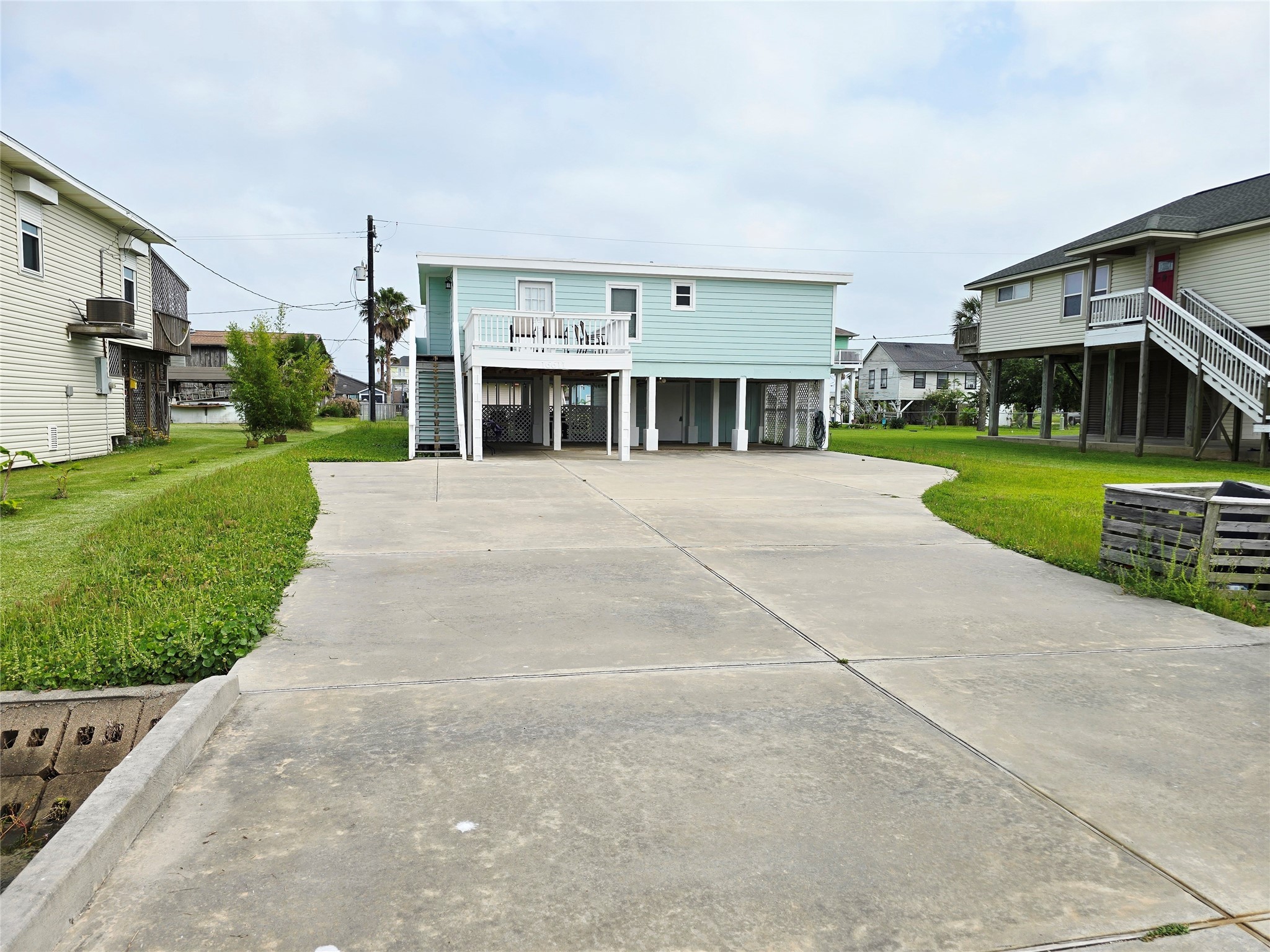 16611 Jolly Roger Road Jamaica Beach, TX 77554 - Photo 3 of 49 a view of a big house with a big yard and large trees