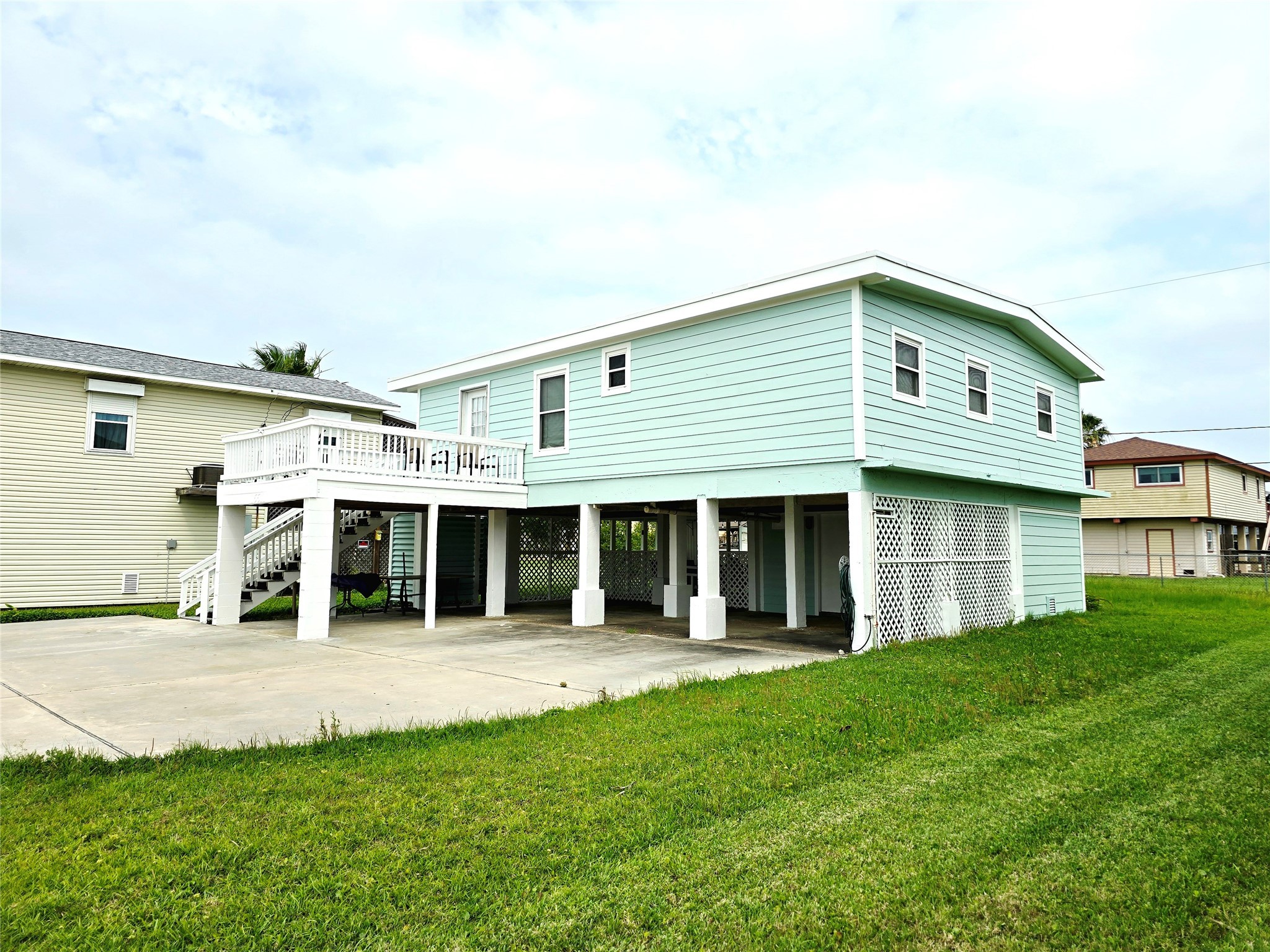16611 Jolly Roger Road Jamaica Beach, TX 77554 - Photo 4 of 49 a view of a white house with a big yard and large trees