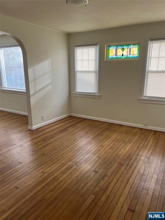 263 Sutton Avenue Hackensack, NJ 07601 - Photo 3 of 11 an empty room with wooden floor and windows