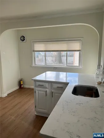 a kitchen with a sink and a stove with wooden floor