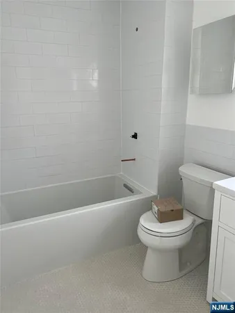a white toilet sitting next to a bath tub