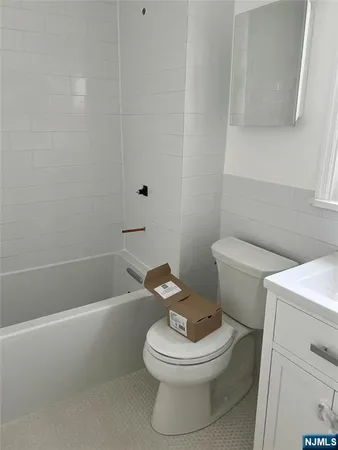 a white toilet and tub sitting next to a bathroom sink