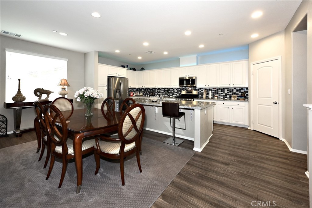 443 Stratus Lane, Unit 4 Simi Valley, CA 93065 - Photo 12 of 32 a kitchen with a dining table chairs and wooden floor