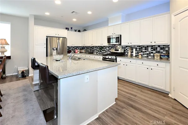 a kitchen with stainless steel appliances a sink stove refrigerator and cabinets