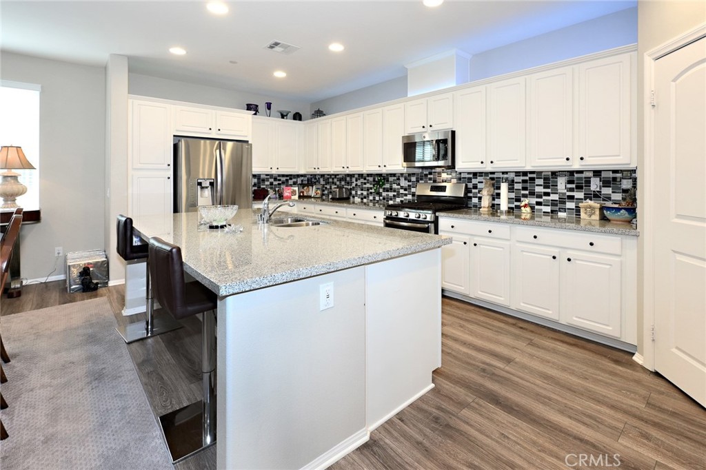 443 Stratus Lane, Unit 4 Simi Valley, CA 93065 - Photo 13 of 32 a kitchen with stainless steel appliances a sink stove refrigerator and cabinets