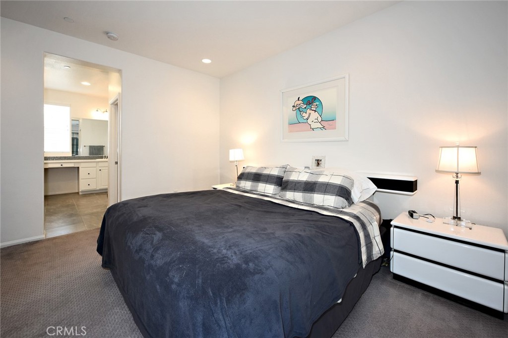 443 Stratus Lane, Unit 4 Simi Valley, CA 93065 - Photo 20 of 32 a bedroom with a bed and a chandelier