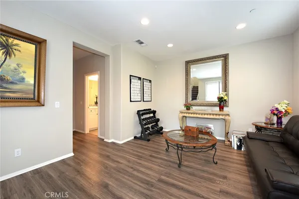 a living room with furniture and a wooden floor