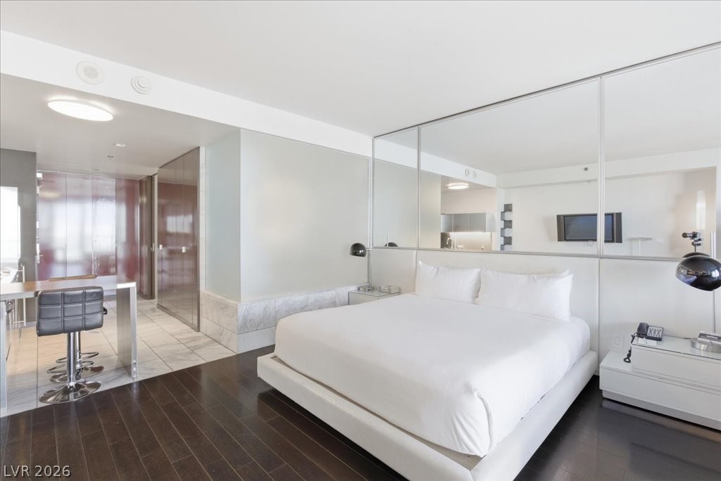 4381 West Flamingo Road, Unit 10306 Las Vegas, NV 89103 - Photo 7 of 26 An inviting sleeping area features rich dark hardwood floors and ample lighting.