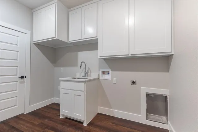 a kitchen with granite countertop white cabinets and a wooden floor