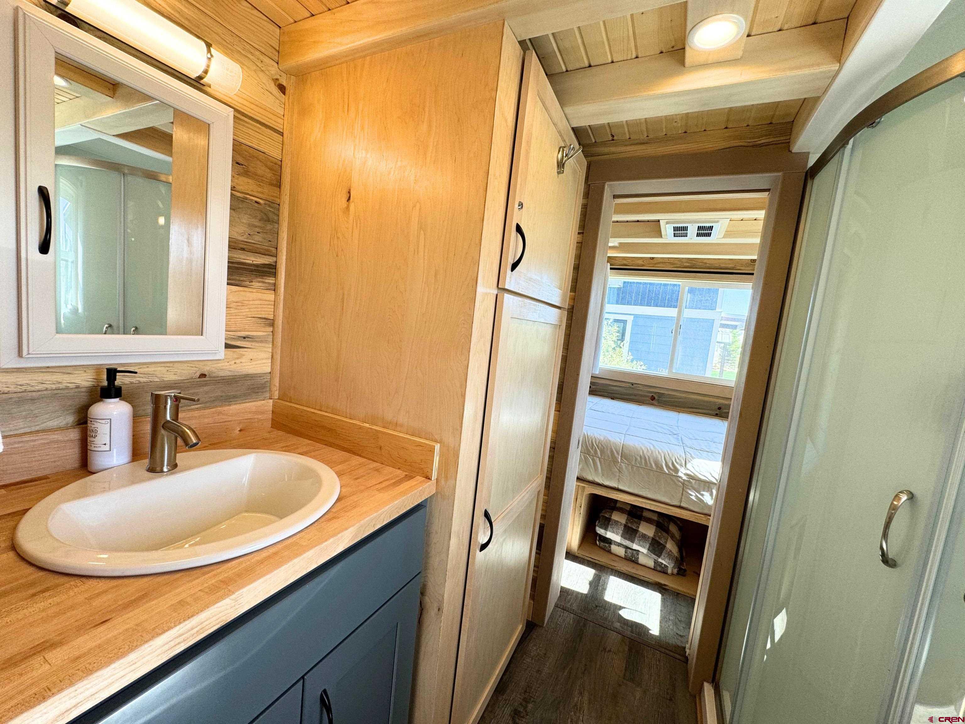 22130 6850 Road, Unit 211 Montrose, CO 81403 - Photo 15 of 25 a bathroom with a sink a mirror and a shower
