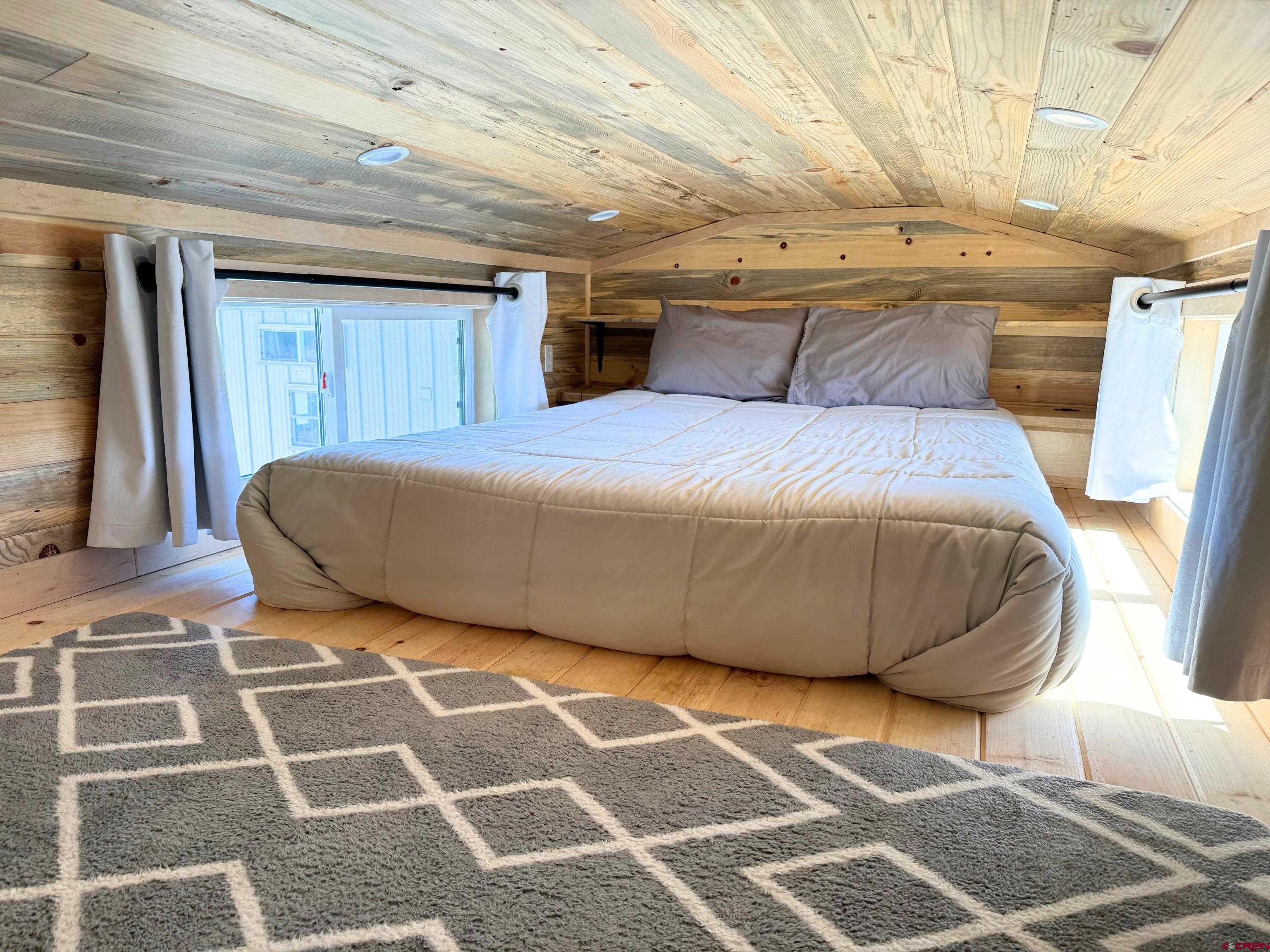 22130 6850 Road, Unit 211 Montrose, CO 81403 - Photo 7 of 25 a bedroom with a bed and a mirror