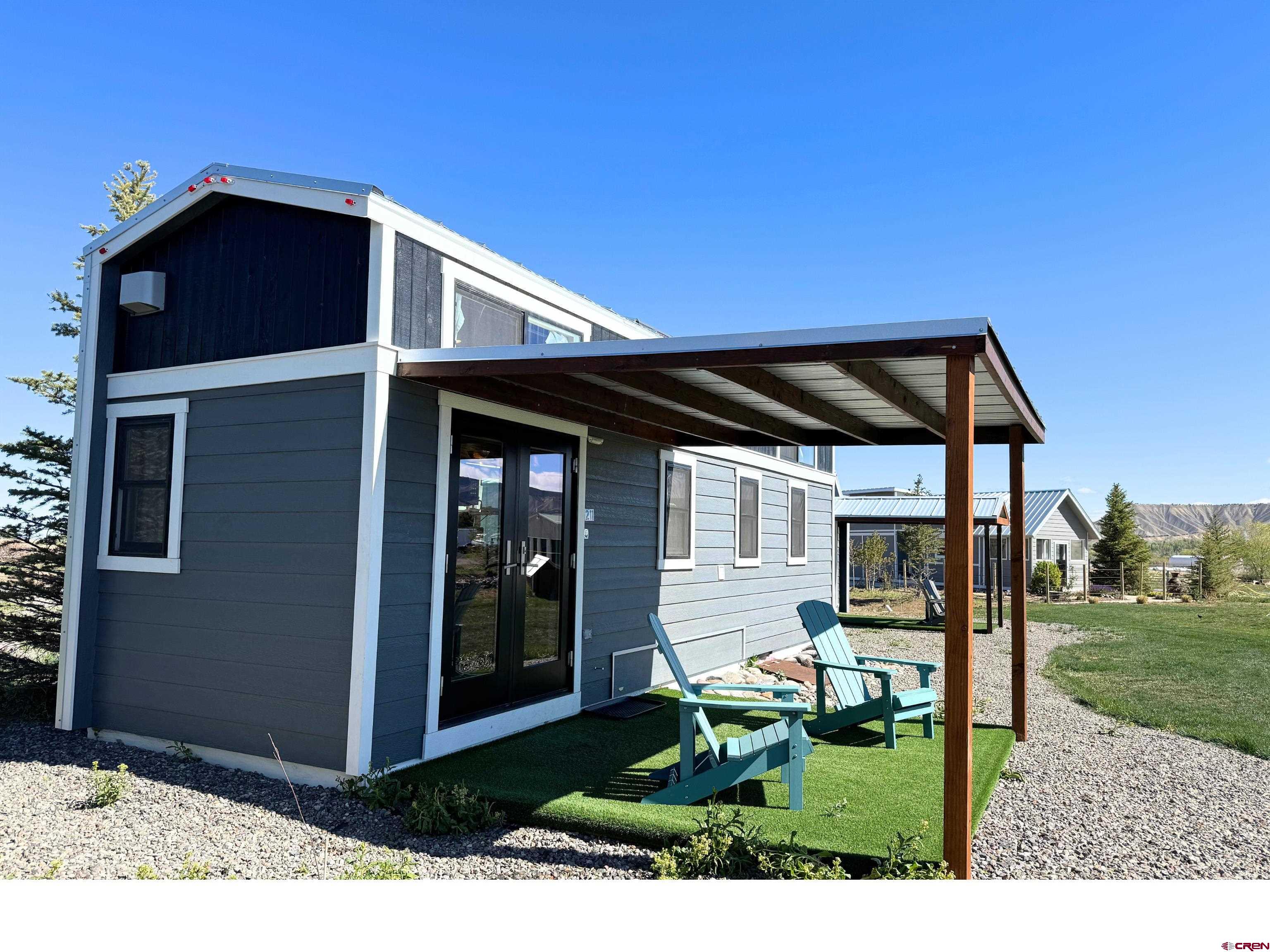 22130 6850 Road, Unit 211 Montrose, CO 81403 - Photo 10 of 25 a black house with yard in front of it