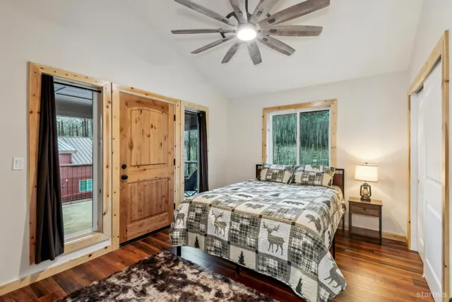 a bedroom with a bed table and a large mirror