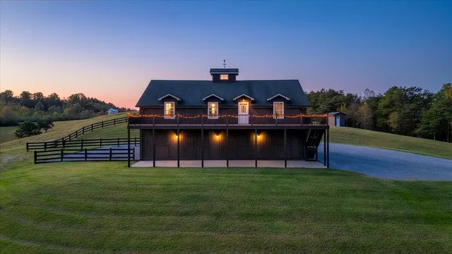 a kitchen with stainless steel appliances a sink a stove a refrigerator cabinets and a dining table with wooden floor