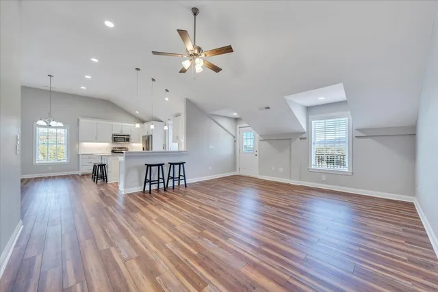 a view of a room with wooden floor a ceiling fan and wooden floor