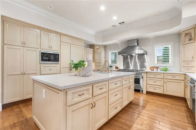 a kitchen with granite countertop a sink stainless steel appliances and white cabinets