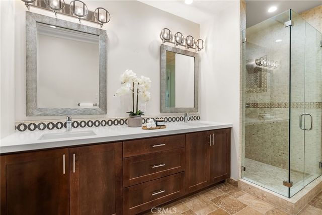 a bathroom with a double vanity sink mirror and shower
