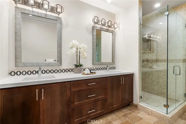 a bathroom with a double vanity sink mirror and shower