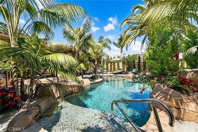 a view of backyard with swimming pool and seating space