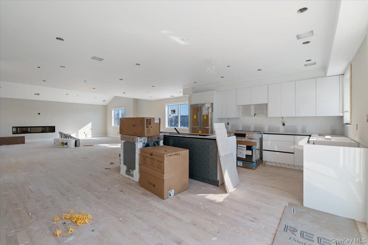 56 Oregon Street Long Beach, NY 11561 - Photo 25 of 25 Kitchen featuring white cabinetry, a kitchen island, stainless steel refrigerator, open floor plan, and range