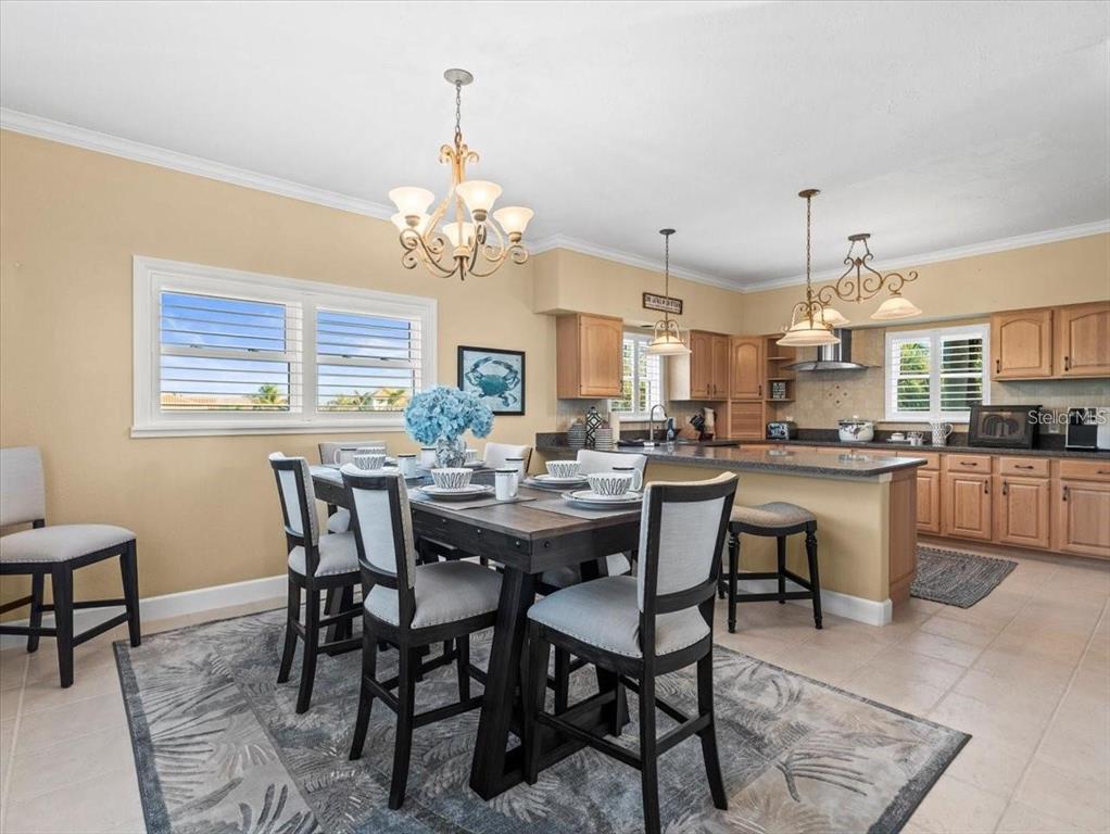 8030 Manasota Key Road Englewood, FL 34223 - Photo 25 of 67 a view of a dining room with furniture a chandelier and wooden floor