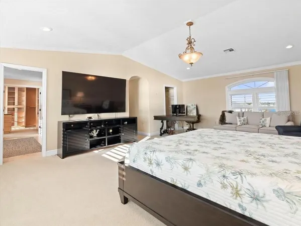 a living room with furniture a flat screen tv and kitchen view