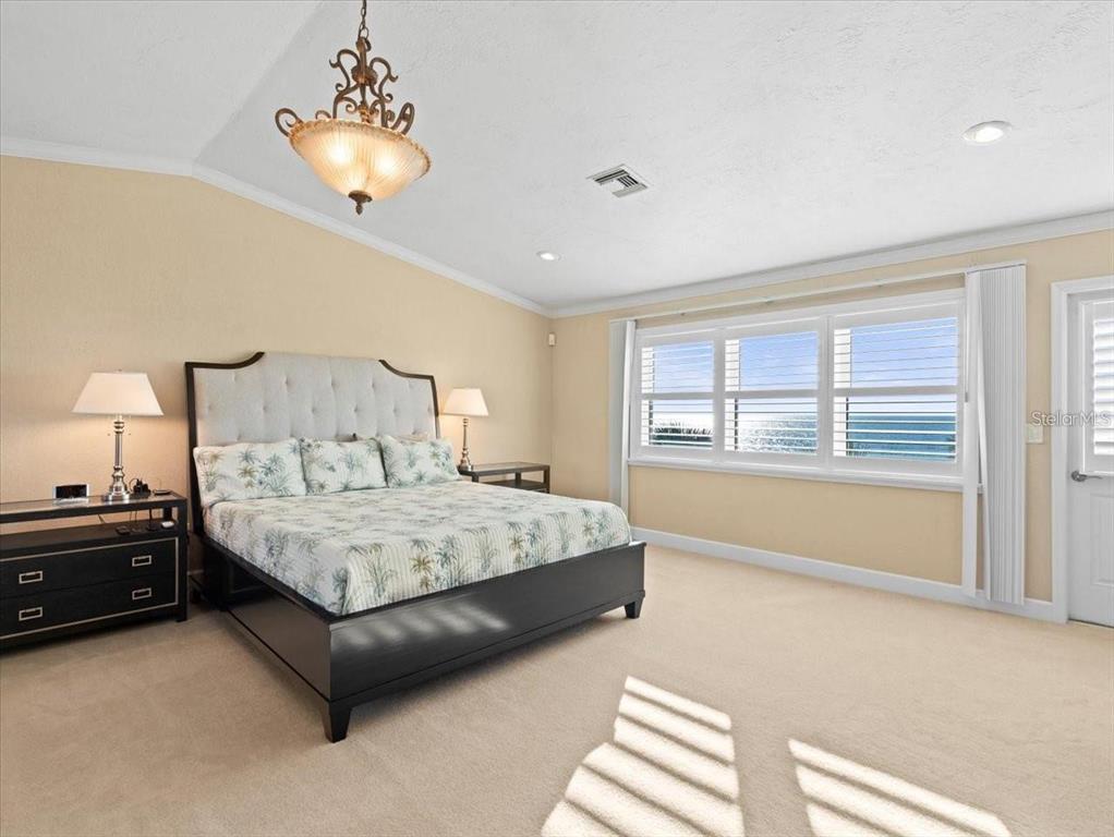 8030 Manasota Key Road Englewood, FL 34223 - Photo 35 of 67 a spacious bedroom with a bed and a chandelier