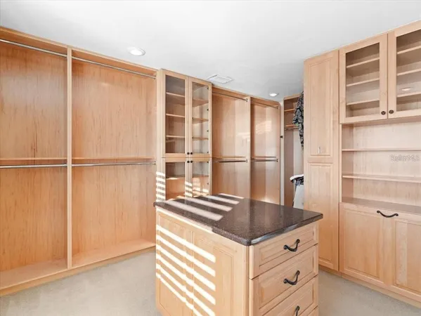 a kitchen with stainless steel appliances granite countertop a sink a stove top oven a chimney and a counter top space