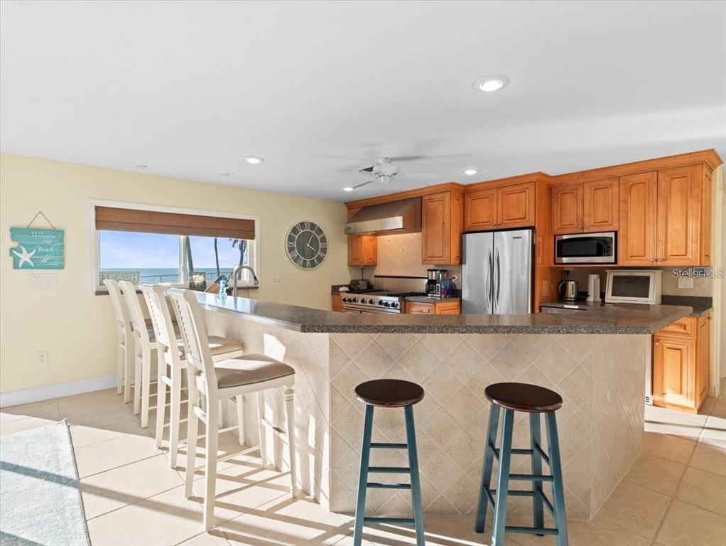 8030 Manasota Key Road Englewood, FL 34223 - Photo 50 of 67 a kitchen with stainless steel appliances a table and chairs in it